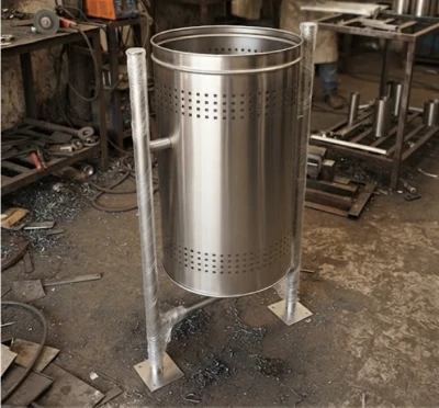 Stainless steel perforated pole mounted dustbin in workshop ready for installation